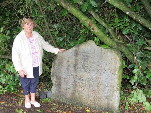 The author's cousin Marion O'Connor stands beside the memorial to John Geoghegan where he was shot by the Black and Tans